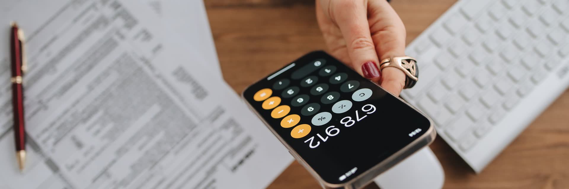 Manos con una calculadora sobre papeles de impuestos